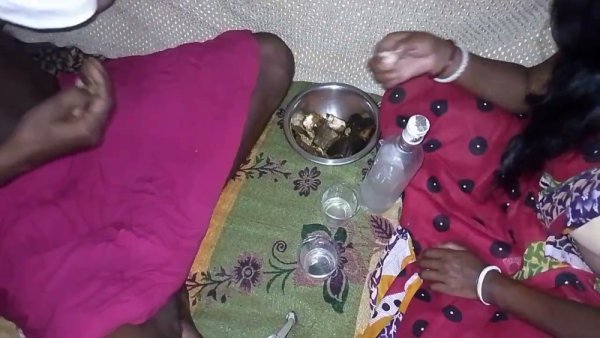 Dark-skinned woman in traditional scarf shares liquor before intimacy on floral blanket on girlsasian.net